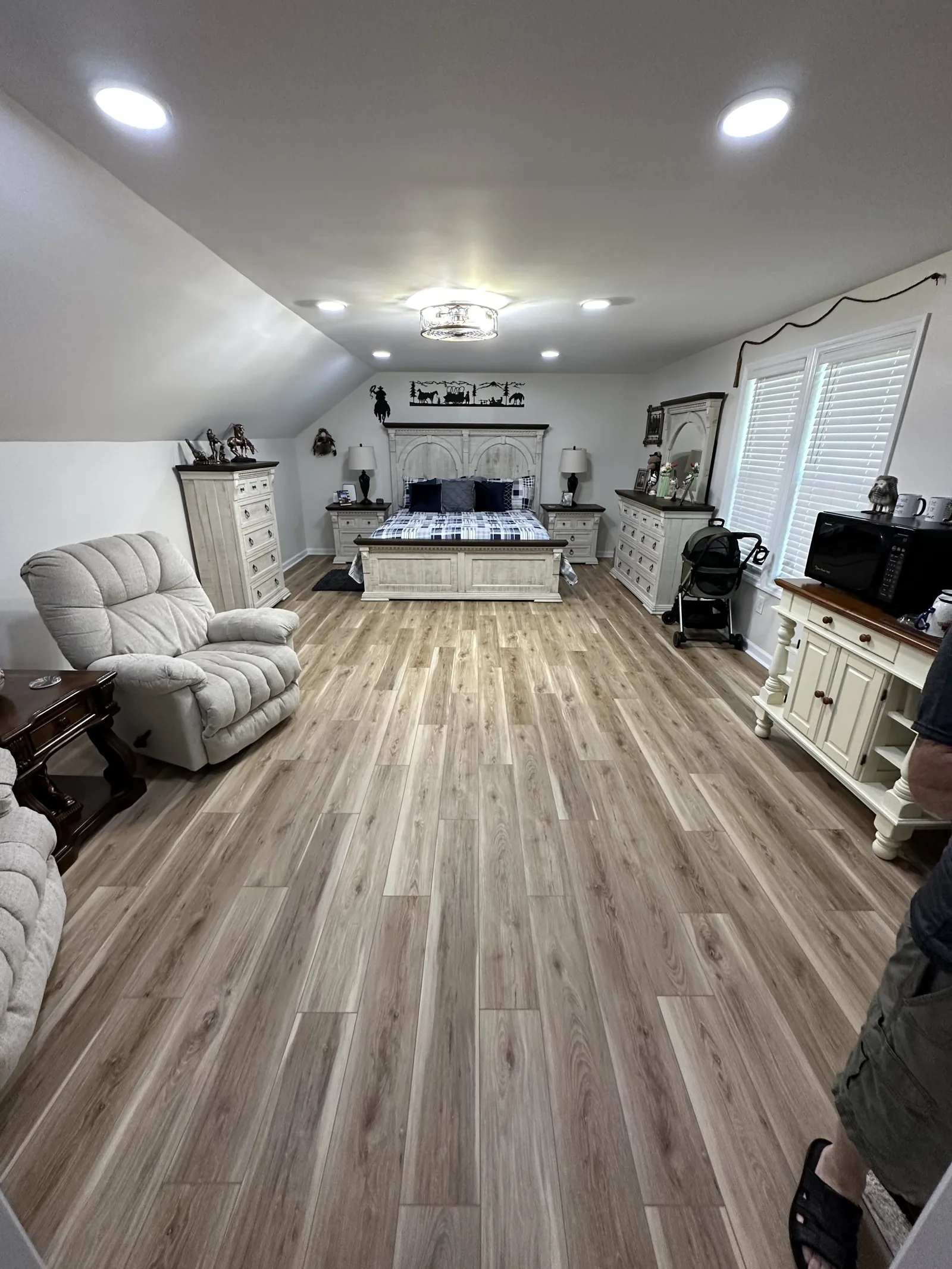 A furnished open living room with wide-plank flooring