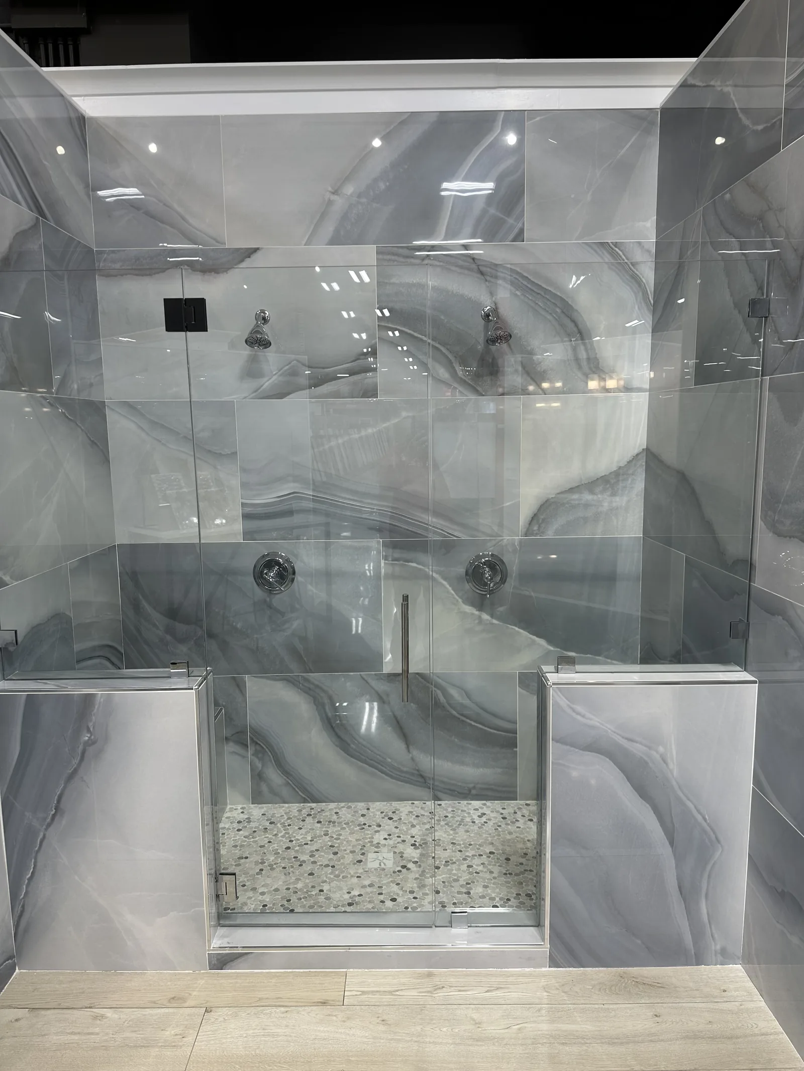 A walk-in shower lined with large-format marble panels and a built-in bench