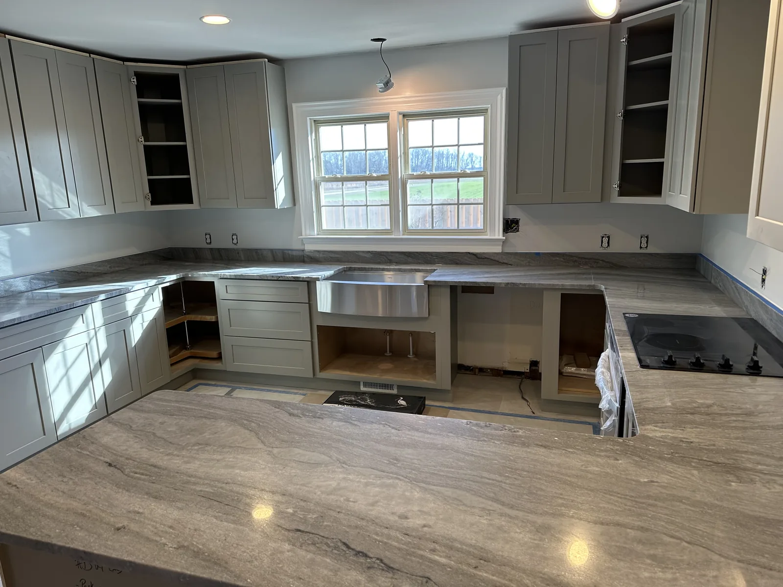 A kitchen mid-build: cabinets hung, worktops in, appliances still to come